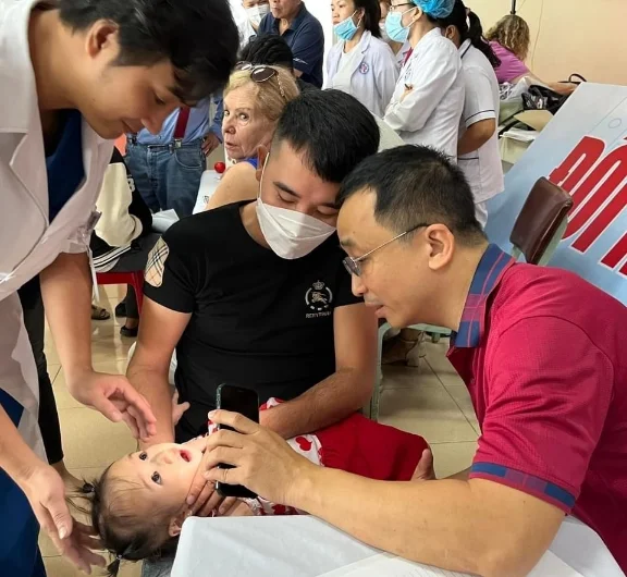 47 trẻ em nghèo khuyết tật được phẫu thuật miễn phí 2 Tiến sĩ Hậu khám em bé bị dị tật vùng mặt